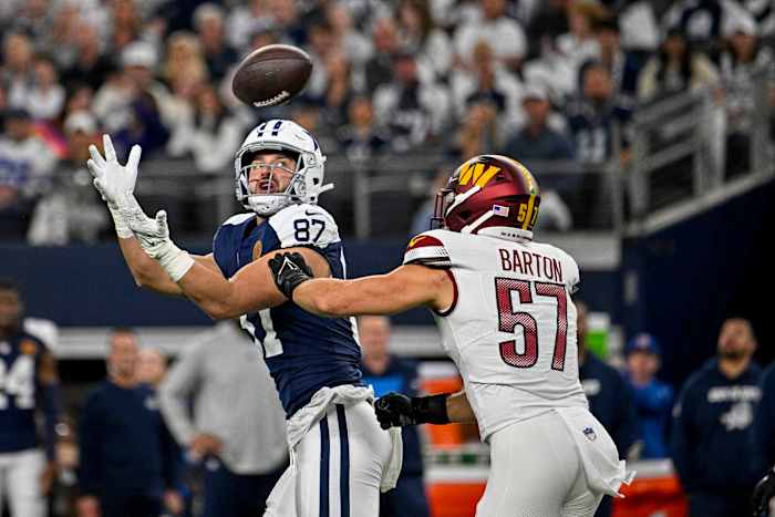 Dallas Cowboys tight end Jake Ferguson (87) catches a pass for a first down over Washington Commanders linebacker Cody Barton (57) during the first quarter at AT&T Stadium.